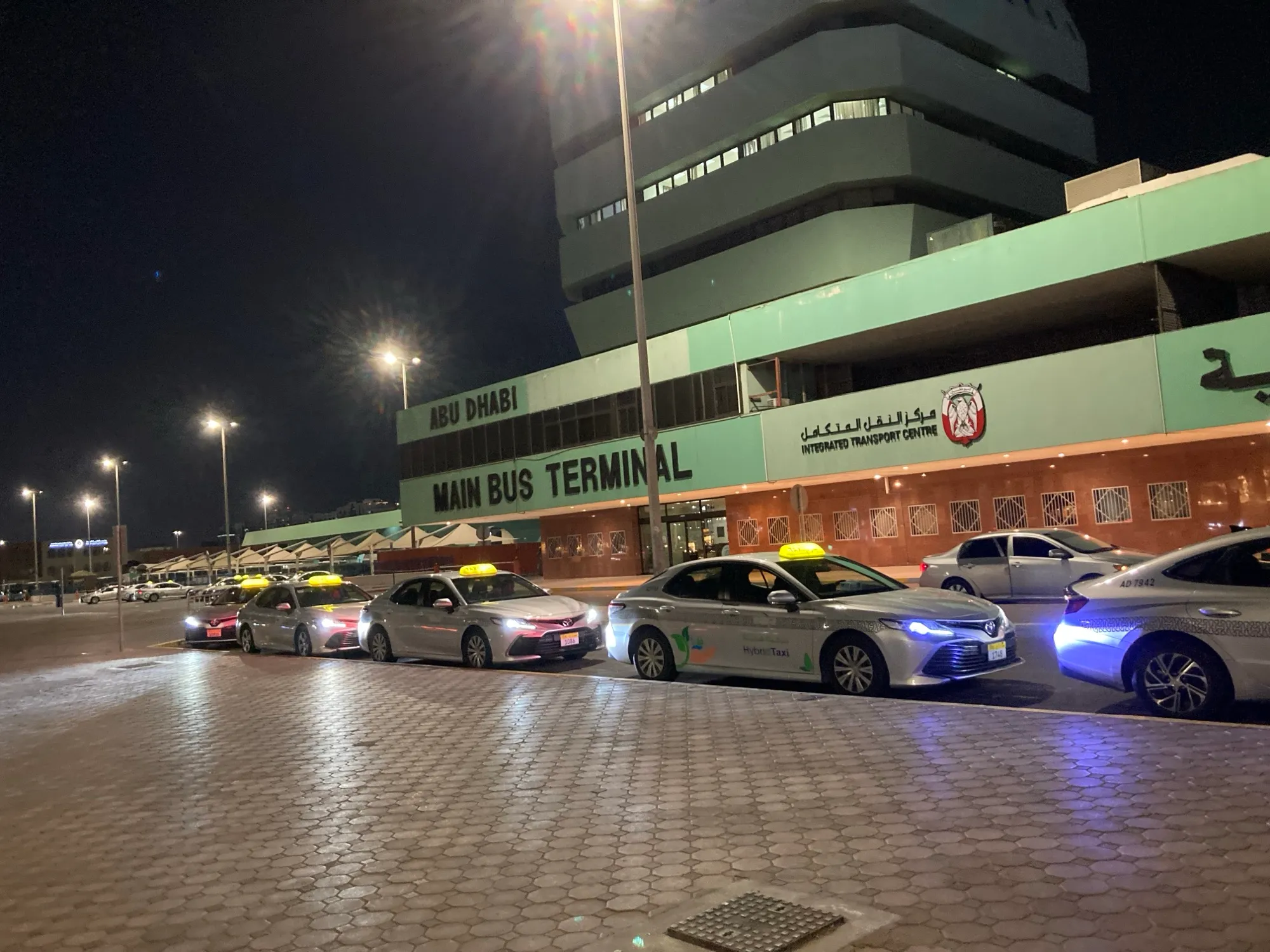 Taxis lined up at night outside the Abu Dhabi Main Bus Terminal