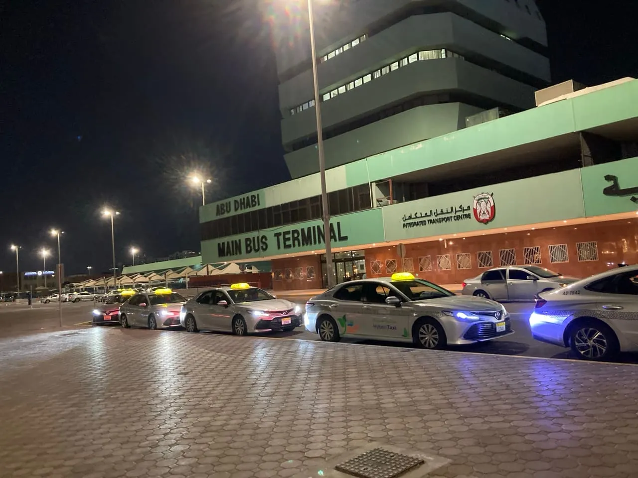 Taxis lined up at night outside the Abu Dhabi Main Bus Terminal