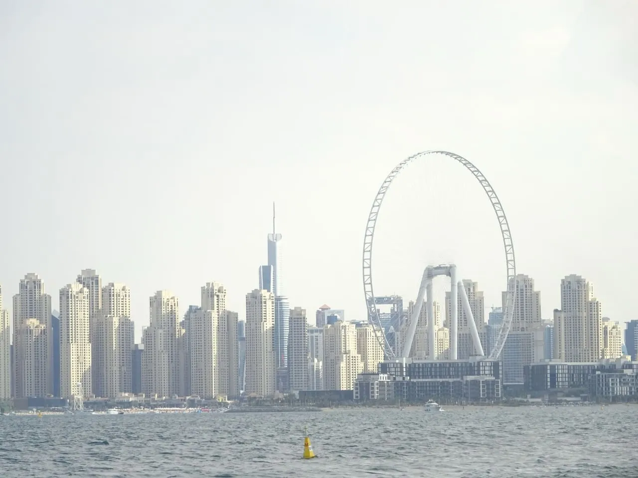 The Ain Dubai wheel on Bluewaters Island in front of the JBR towers, seen from the sea