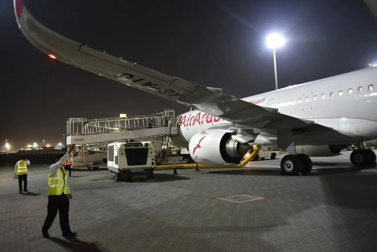 An Air Arabia Airbus A321neo at its stand at Sharjah International Airport at night