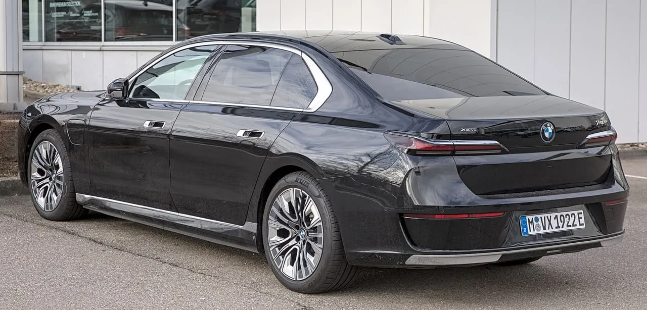 A black BMW 750e, the current 7 Series, seen from the rear three-quarter