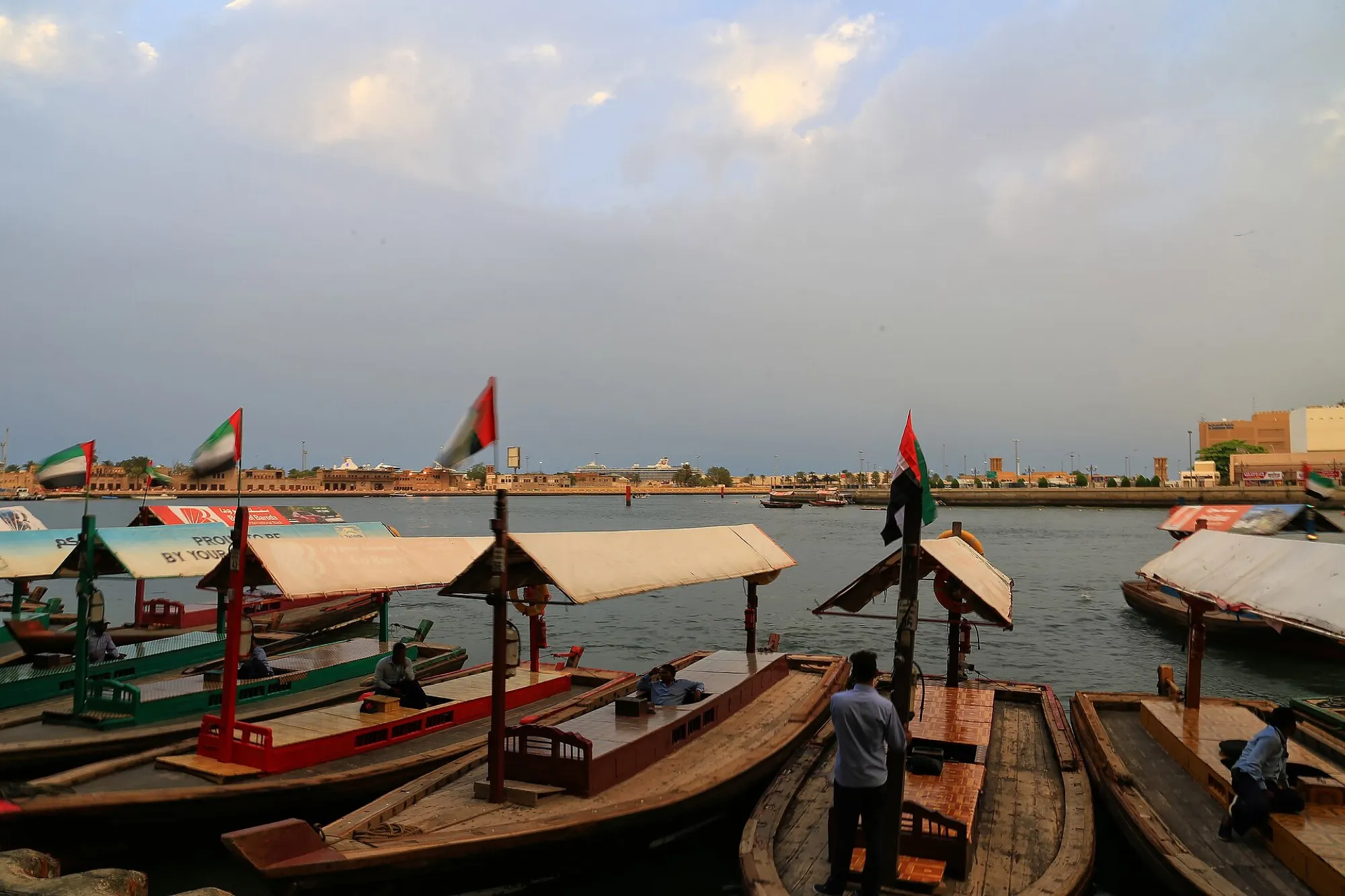 Wooden abras with UAE flags moored at the Bur Dubai abra station on Dubai Creek