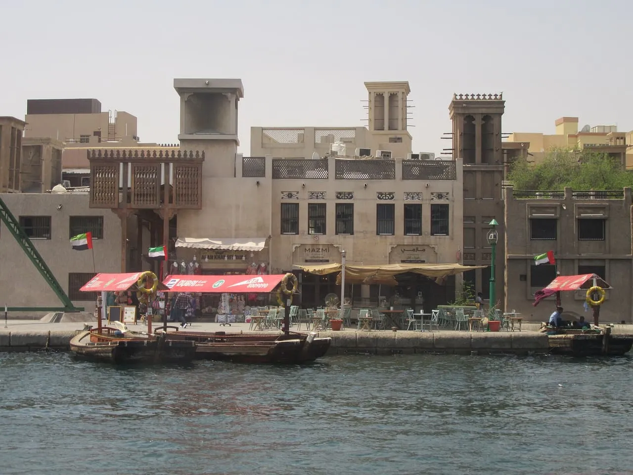 RTA abras moored at the Bur Dubai waterfront, below wind towers and heritage buildings