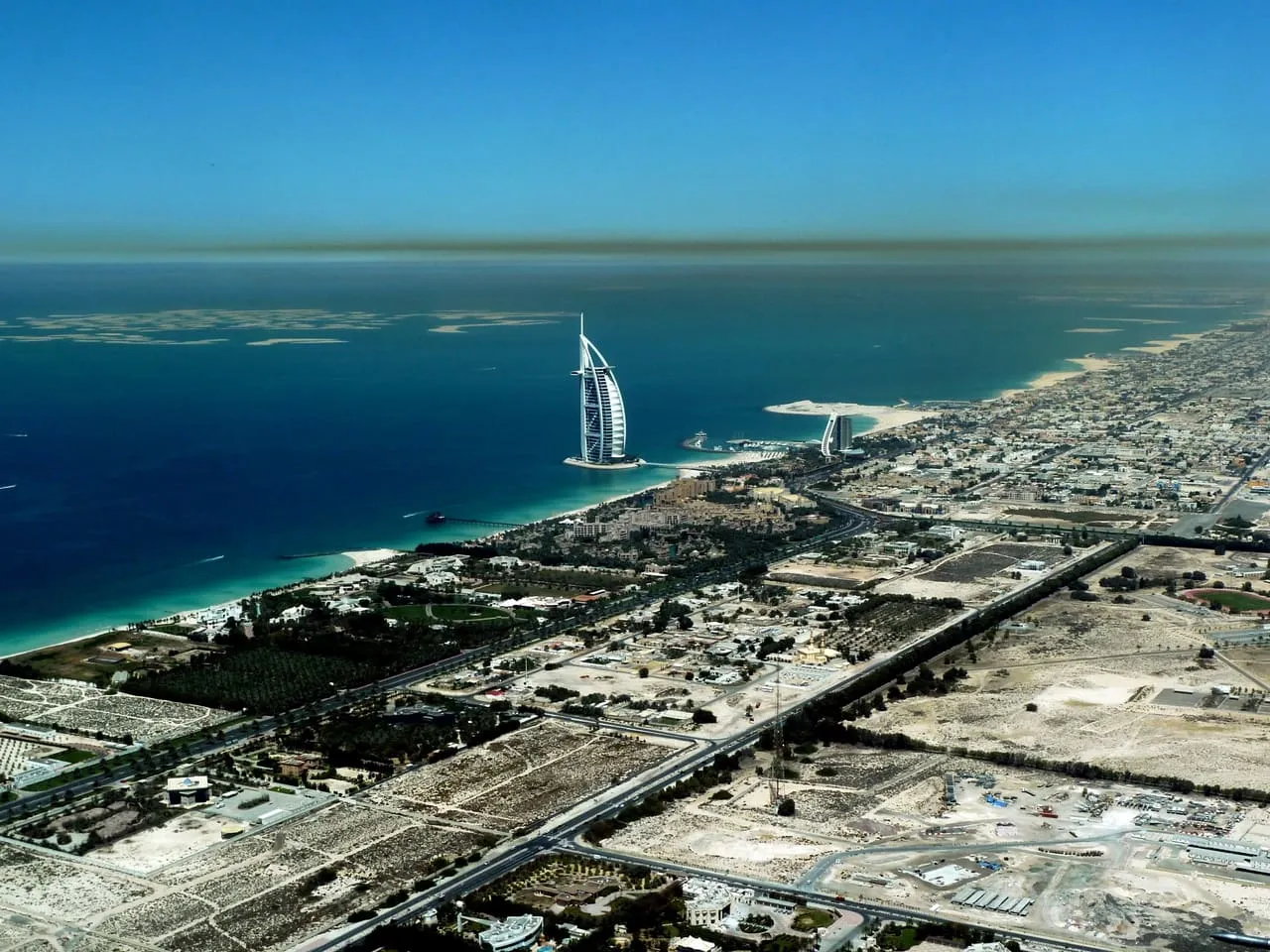 Burj Al Arab and the Jumeirah coastline from the air, with The World islands offshore