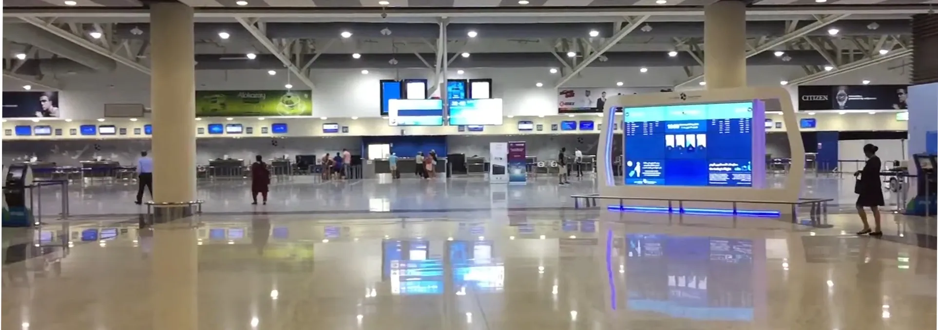 The check-in hall inside the Al Maktoum International passenger terminal, with flight information screens and check-in desks