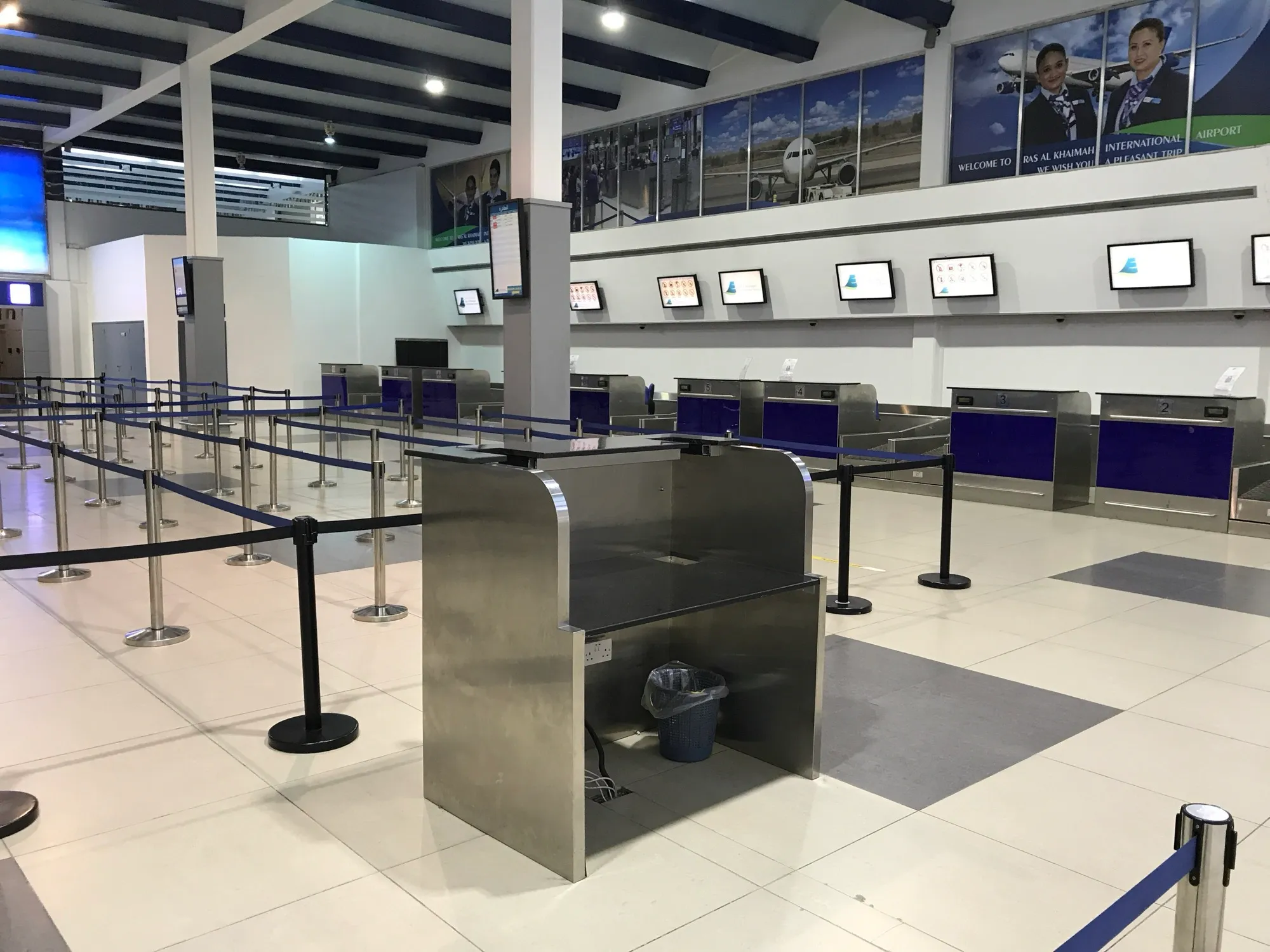 The check-in hall at Ras Al Khaimah International Airport, with queue barriers and the check-in desks