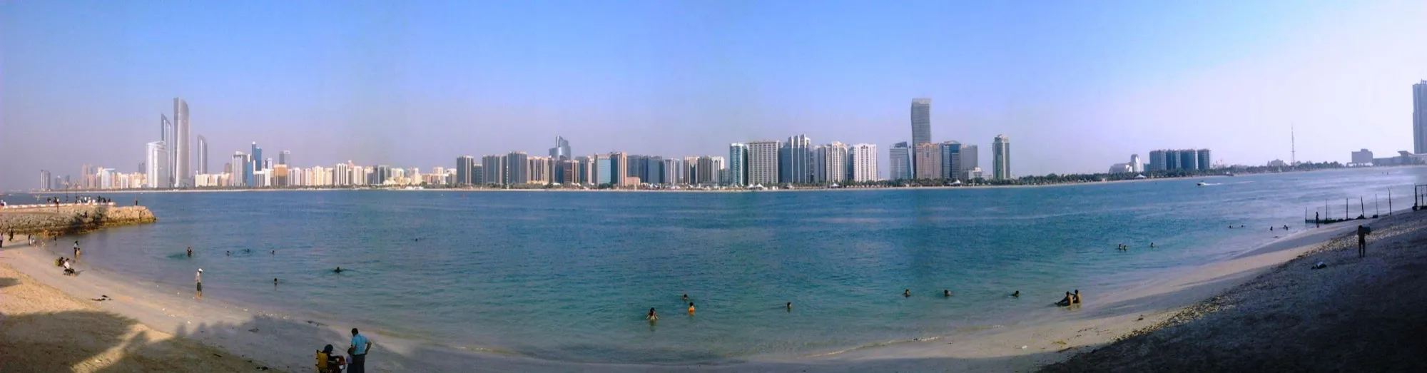 The Abu Dhabi Corniche beach with the downtown skyline across the bay