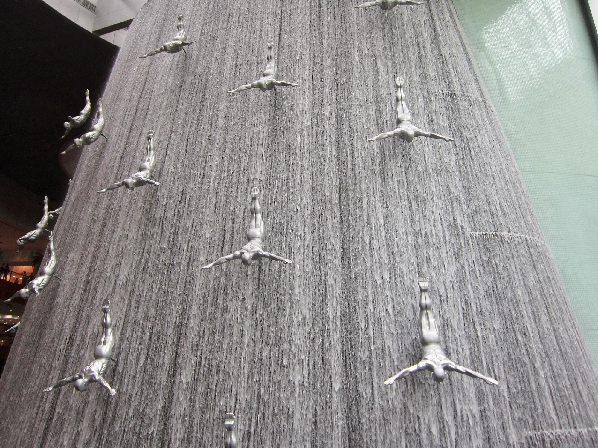 Silver diver sculptures set into the Waterfall wall at The Dubai Mall