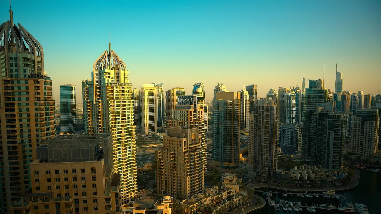 Towers of Dubai Marina in early evening light, with boats moored in the marina below
