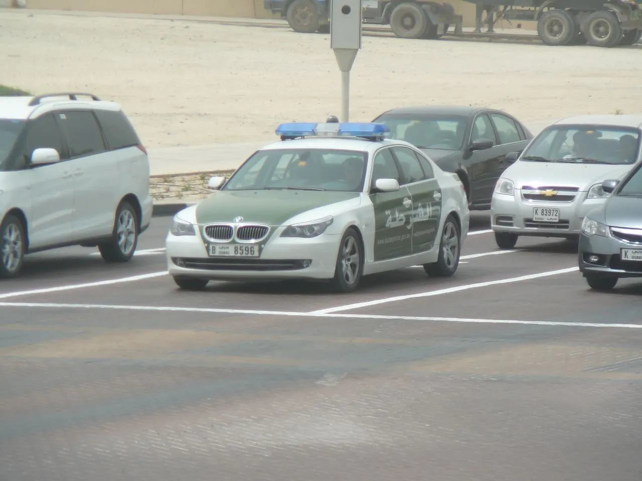 A green and white Dubai Police patrol car in a car park