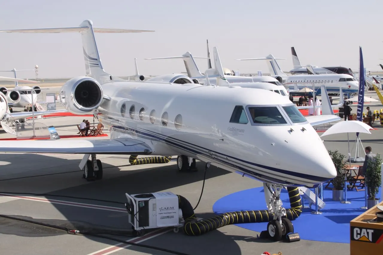 A Gulfstream G450 on the apron at Al Maktoum International, with a ground power unit by the nose wheel
