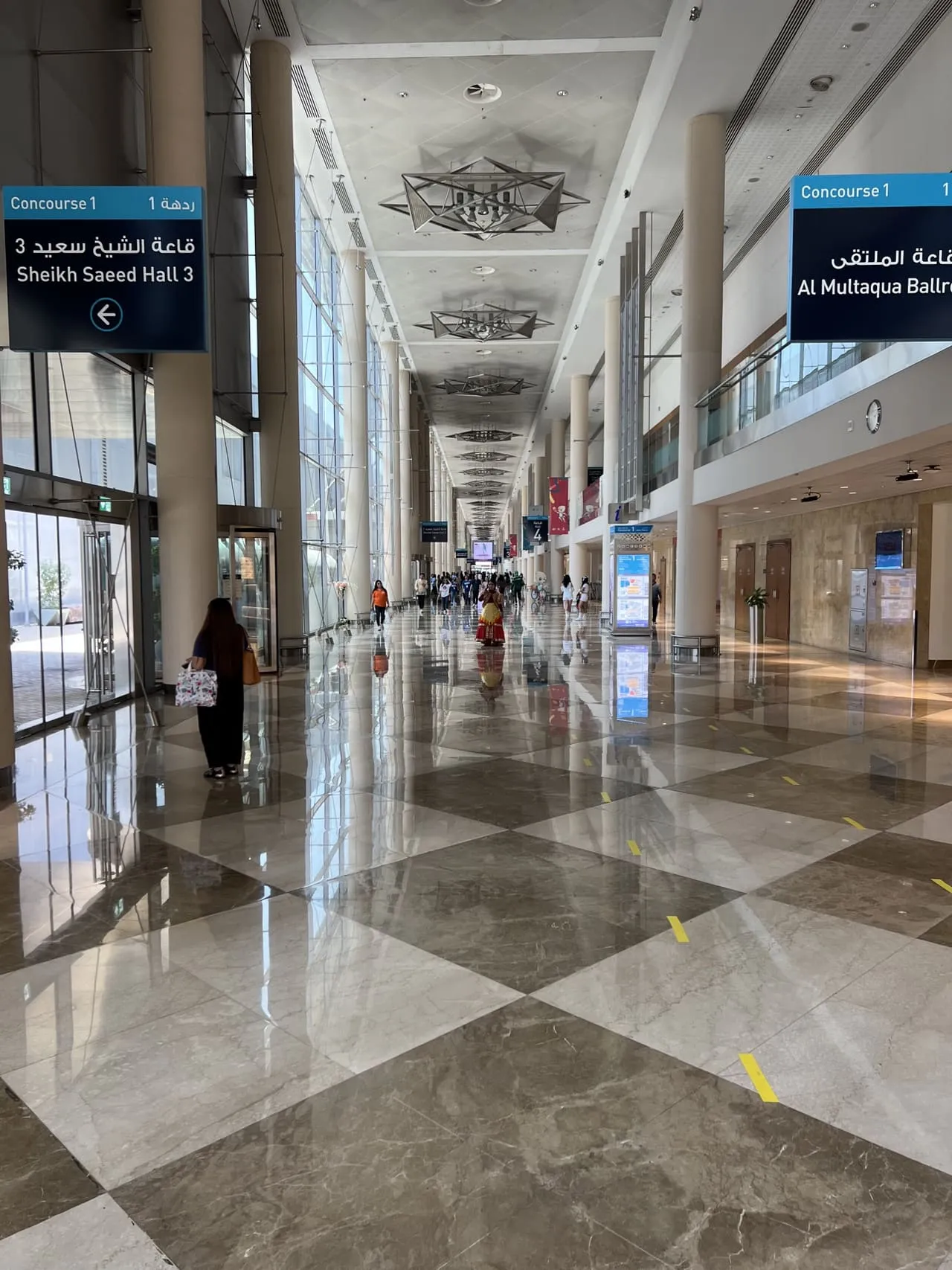 A DWTC concourse with signs to Sheikh Saeed Hall 3 and Al Multaqa Ballroom