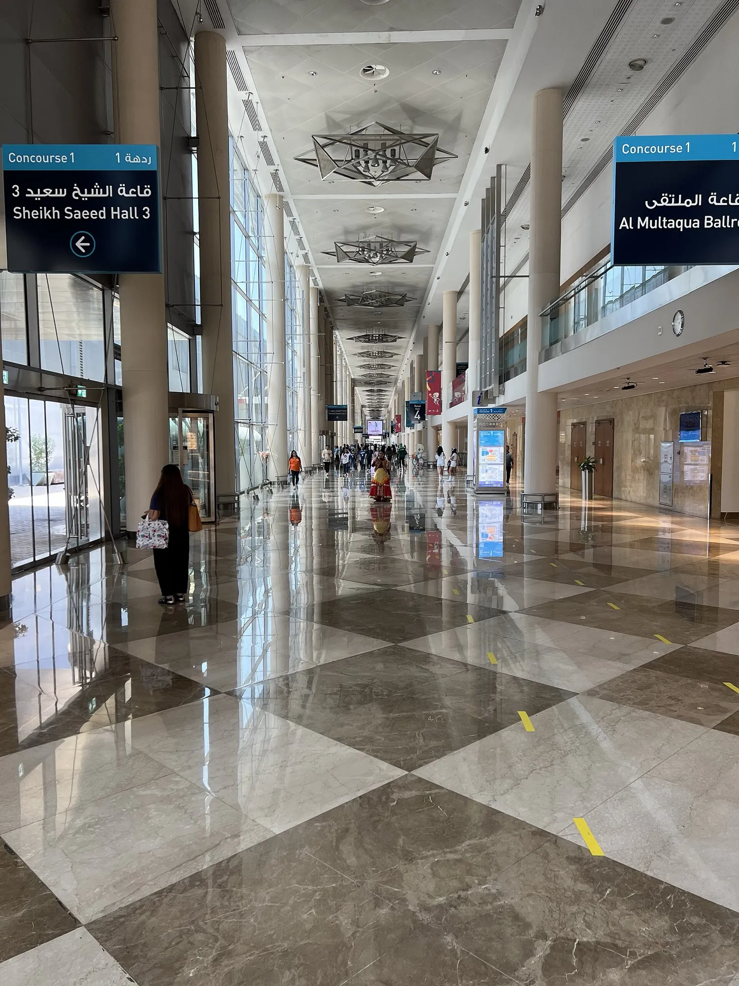 The long Concourse 1 corridor at Dubai World Trade Centre with signs to Sheikh Saeed Hall 3