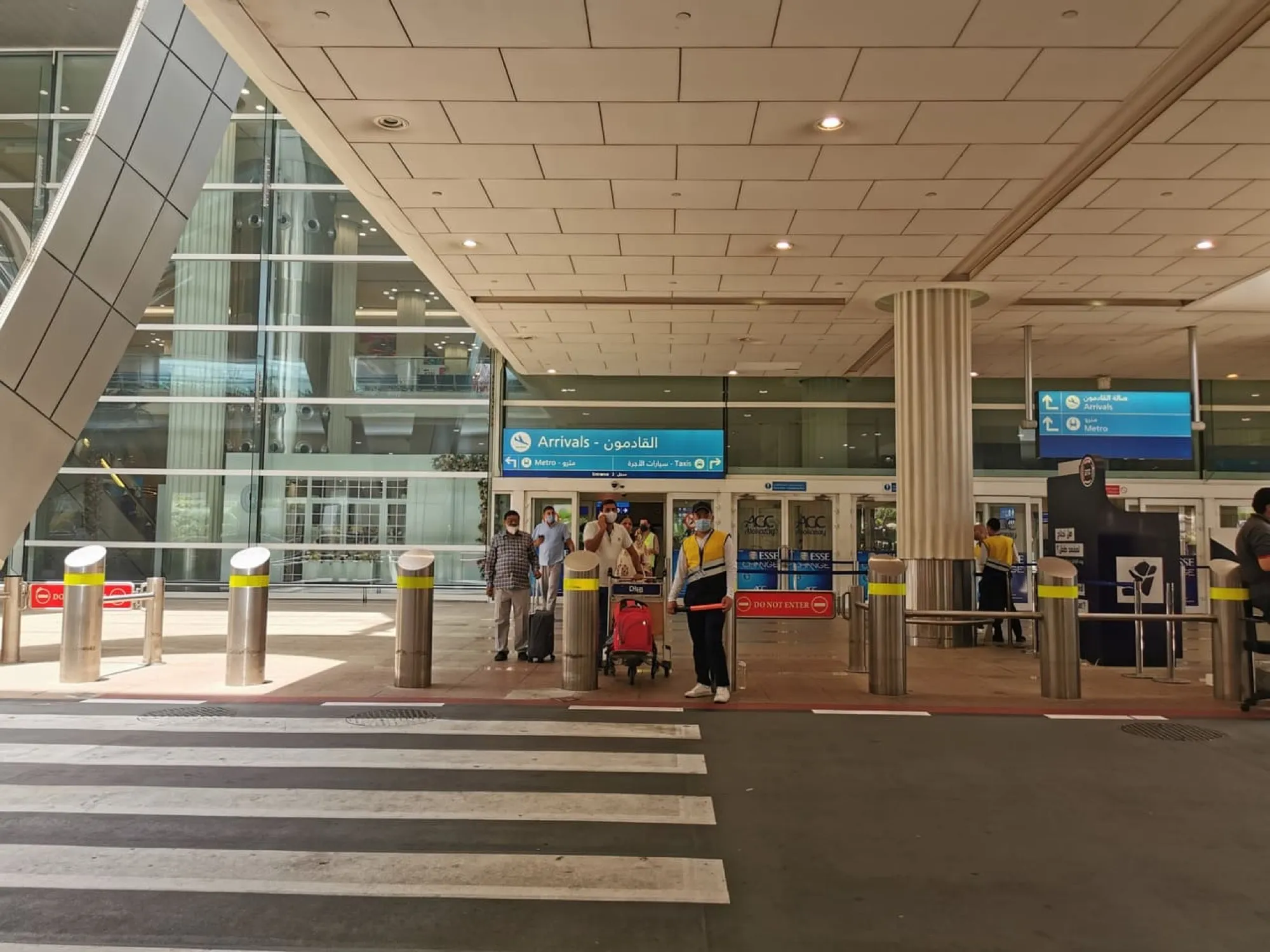 Arrivals exit at Dubai International, with signs to the metro and taxis