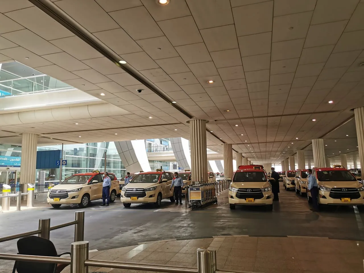 Dubai Taxi cars lined up at the rank under the arrivals canopy at Dubai International