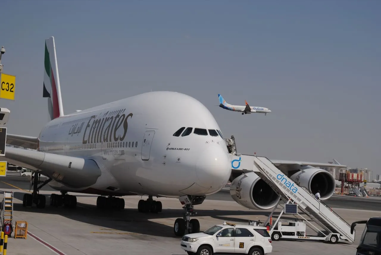 An Emirates Airbus A380 at gate C32 at Dubai International as a flydubai jet comes in to land
