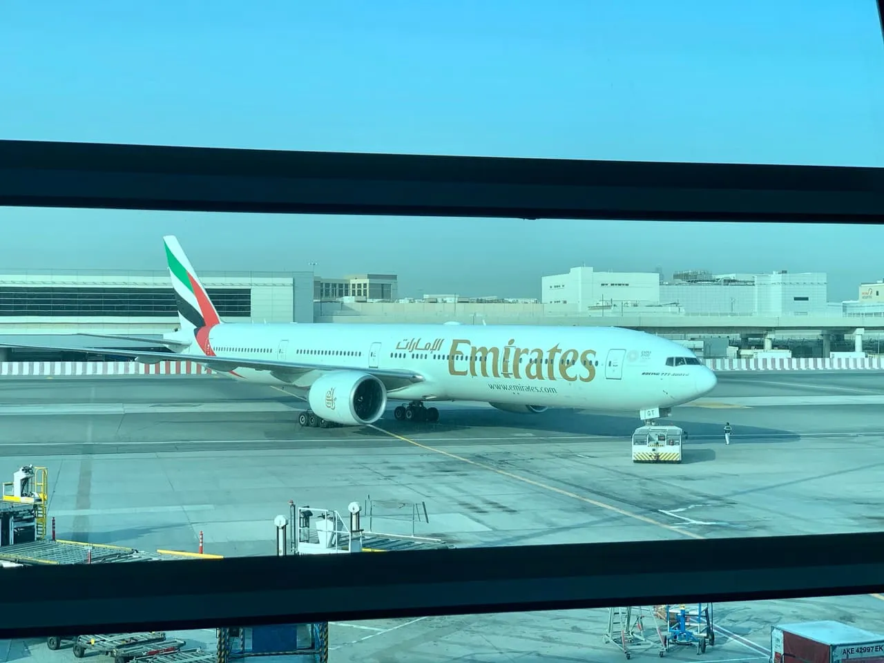 An Emirates Boeing 777-300ER on the apron, seen from a Terminal 3 window at Dubai International