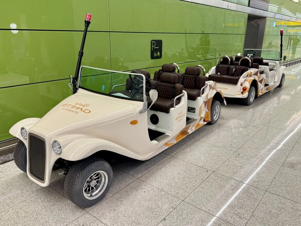 Etihad Airways passenger buggies parked inside Terminal A at Zayed International Airport