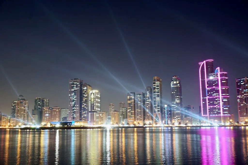 Light beams over the Sharjah waterfront towers at night during the Sharjah Light Festival