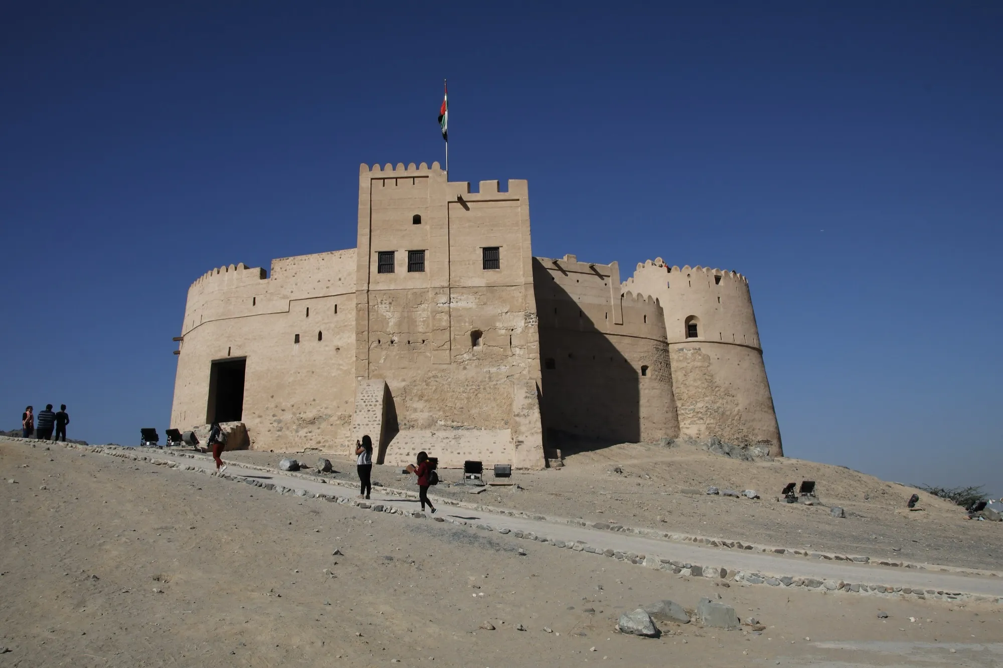 Fujairah Fort, a sand-coloured fort on a hill under a clear blue sky
