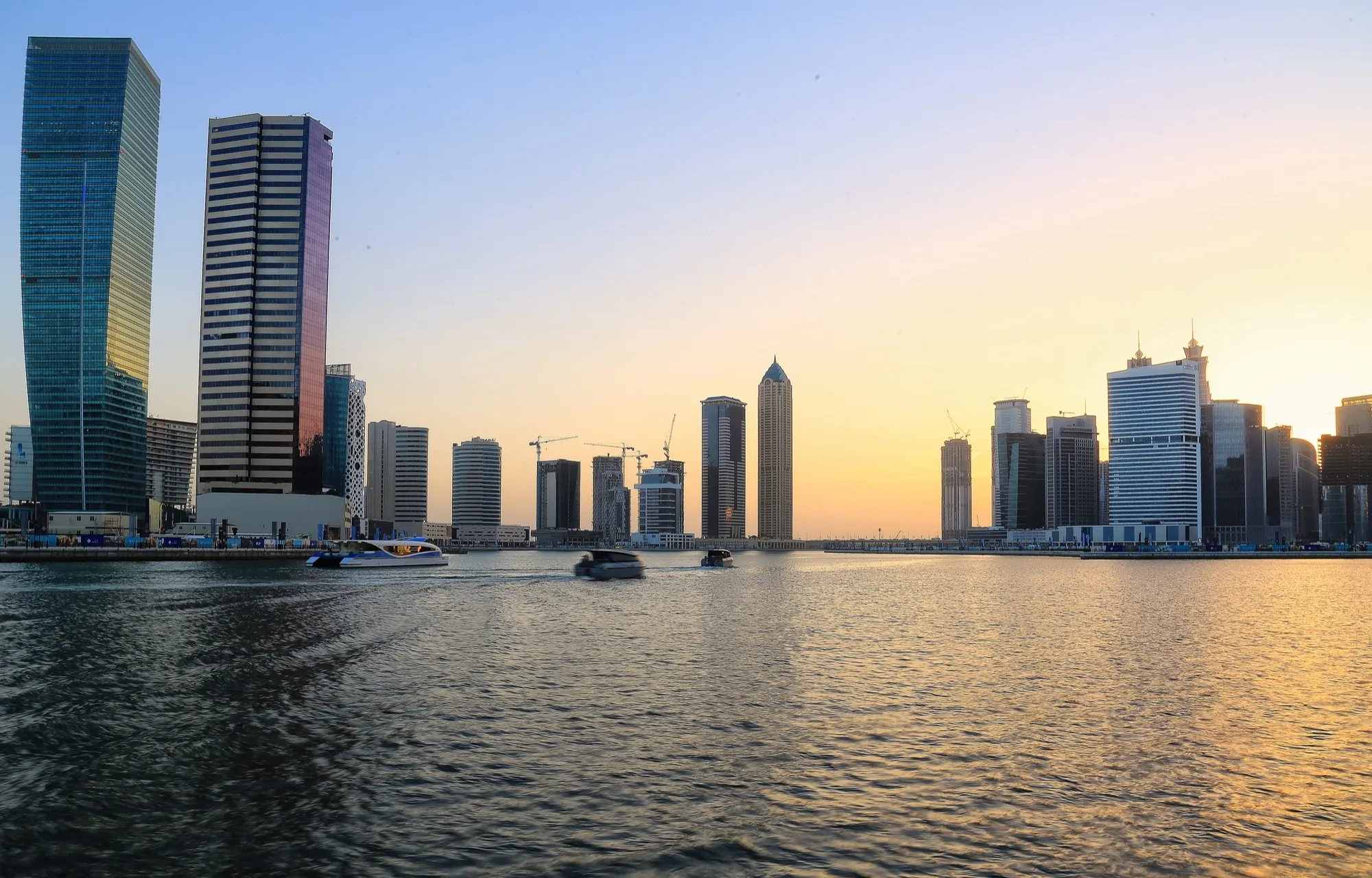 Office towers of Business Bay along the Dubai Water Canal at sunset