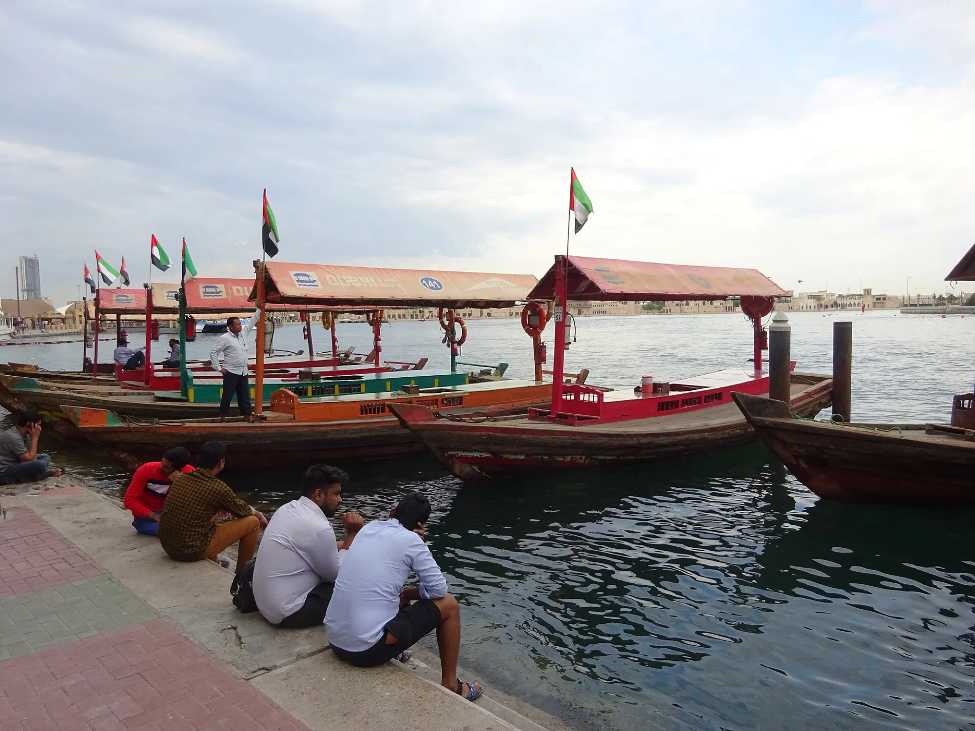 Wooden abra boats with UAE flags moored on Dubai Creek