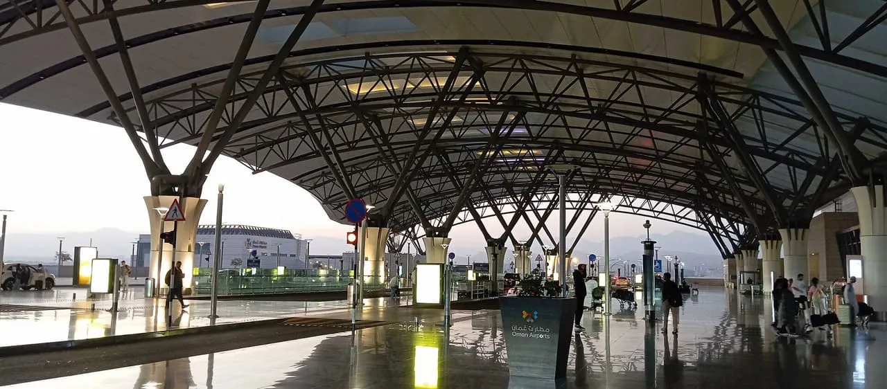 The covered departures forecourt of the passenger terminal at Muscat International Airport at dawn