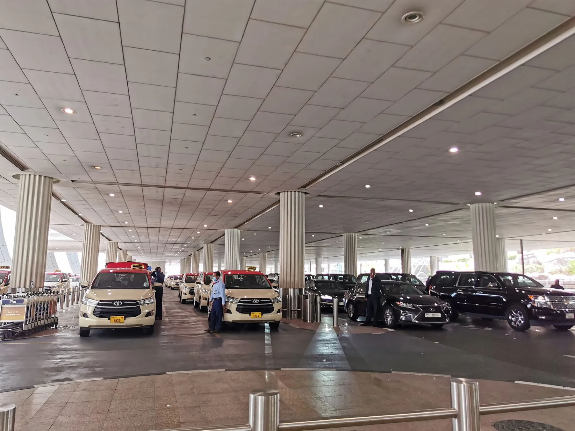 Cream and red RTA taxis lined up at the Dubai International Airport taxi rank