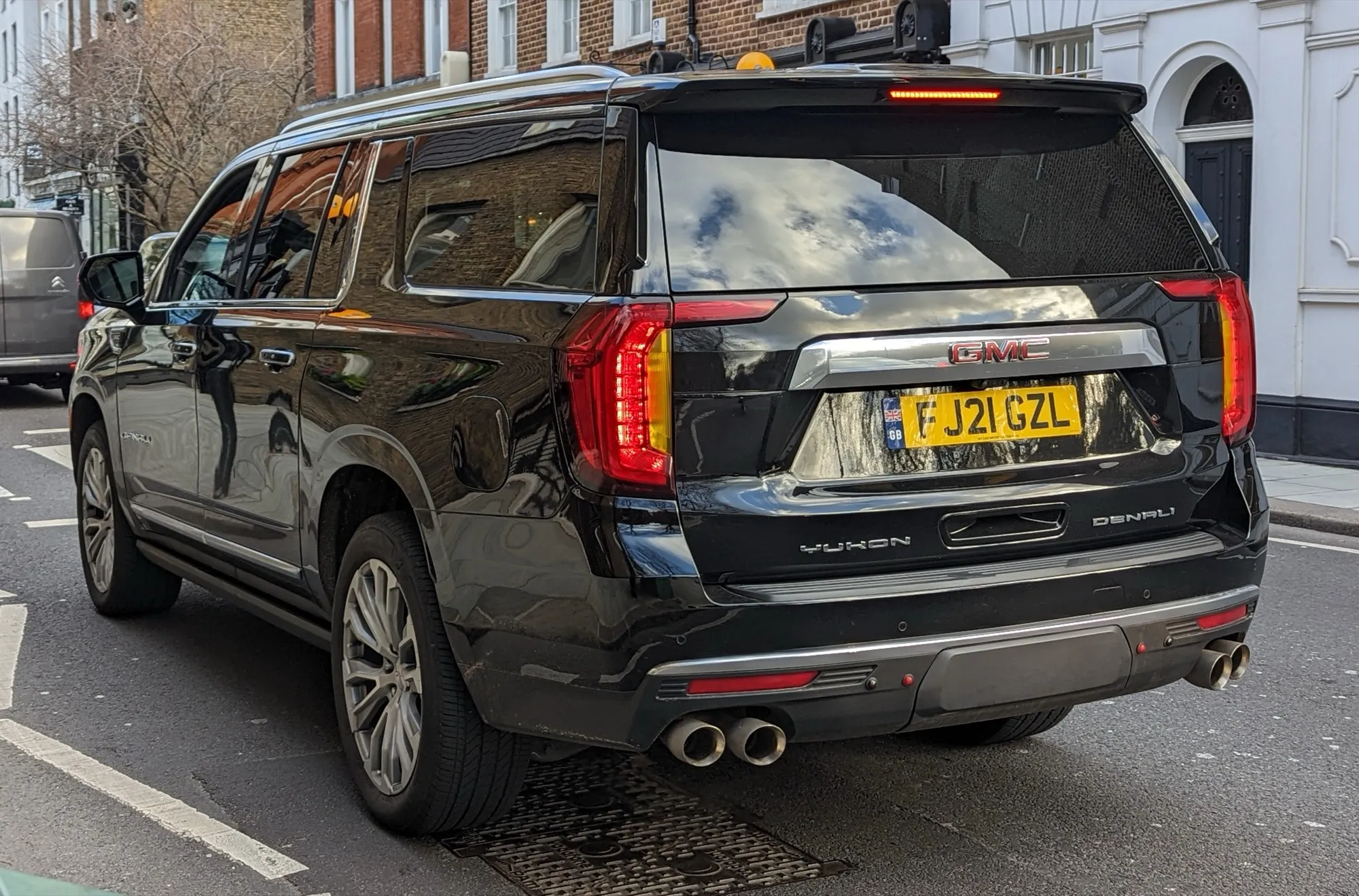 Rear view of a black GMC Yukon Denali SUV parked on a street