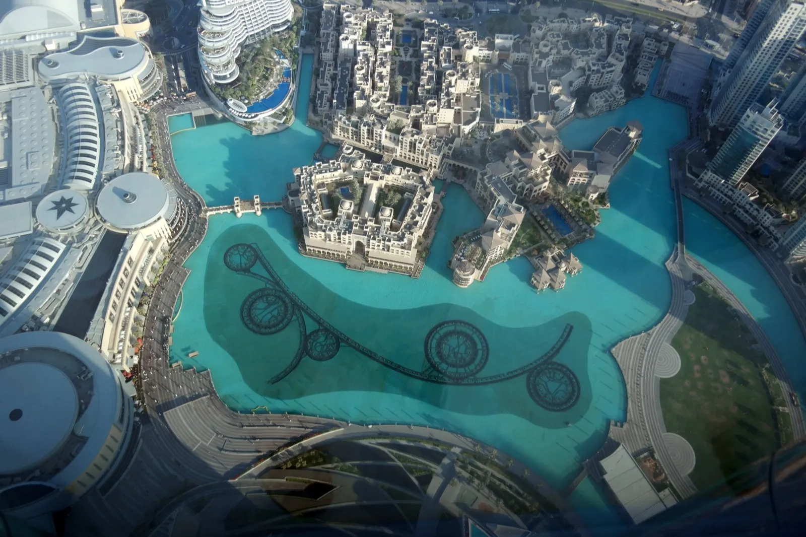 Aerial view from the Burj Khalifa of the Dubai Fountain lake, Dubai Mall and the green lawn of Burj Park
