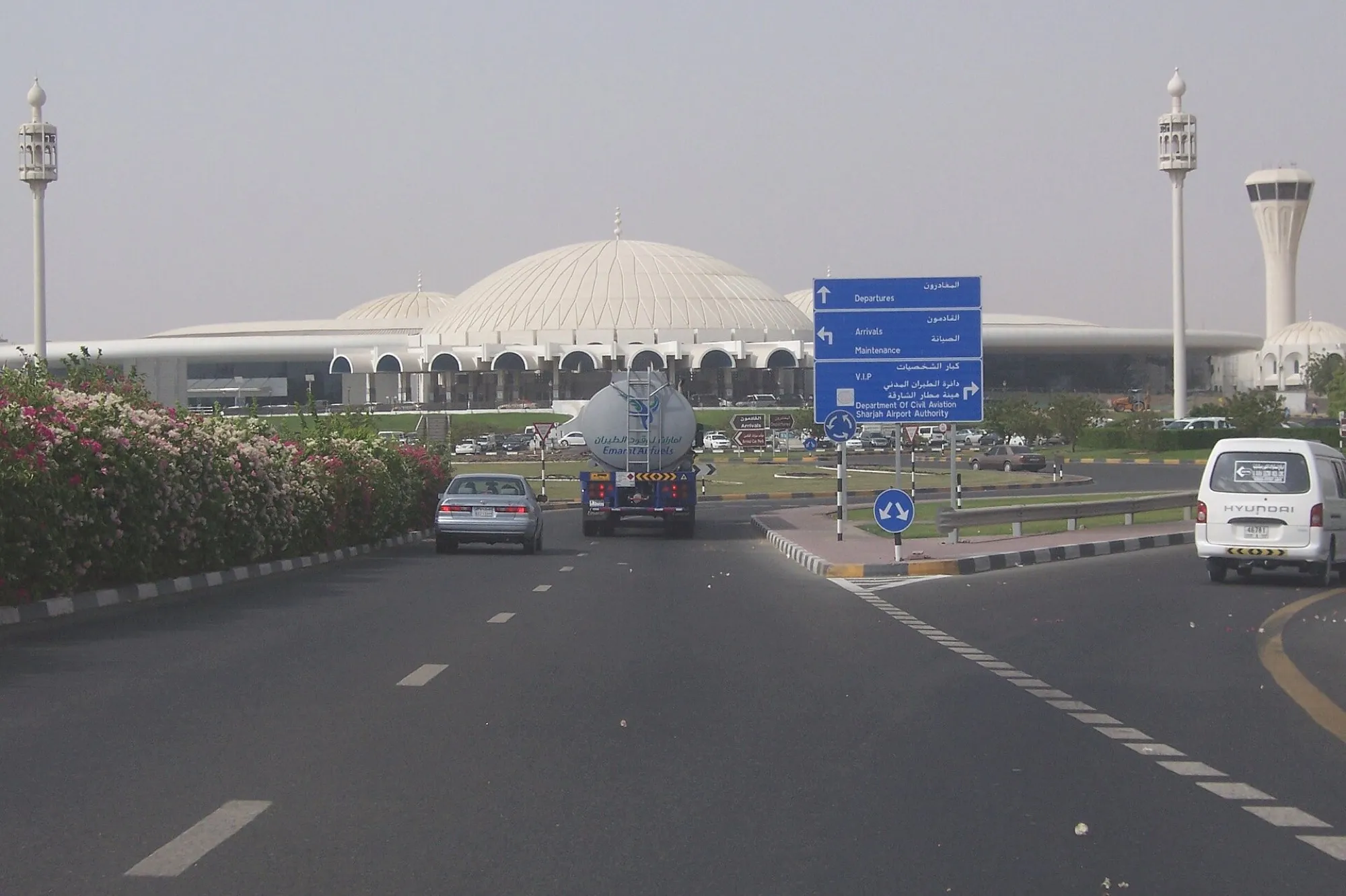 The road into Sharjah International Airport, with the terminal's white domes and the control tower ahead