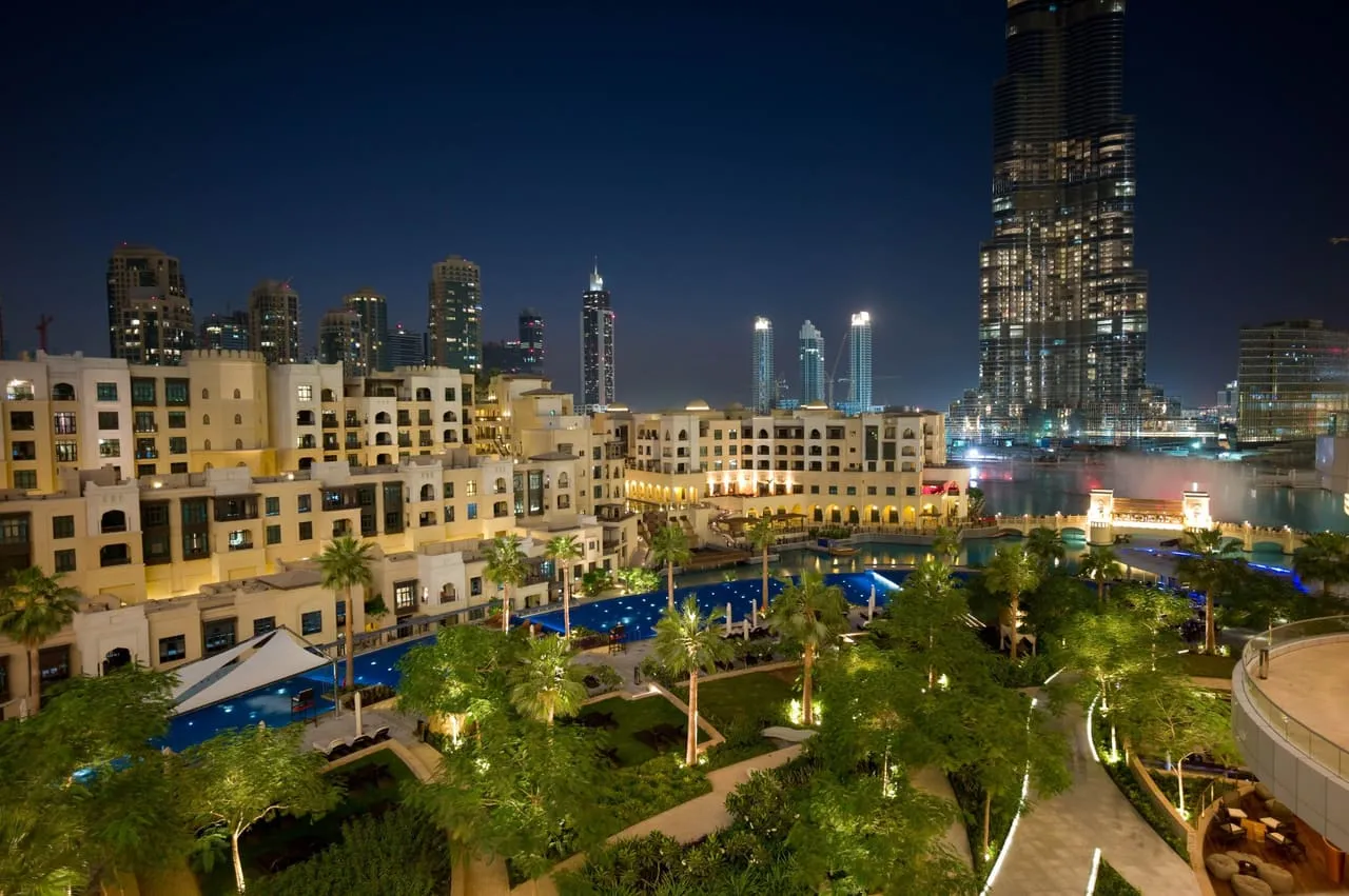 Downtown Dubai at night, with the Burj Khalifa rising above the lake and the low-rise Old Town buildings