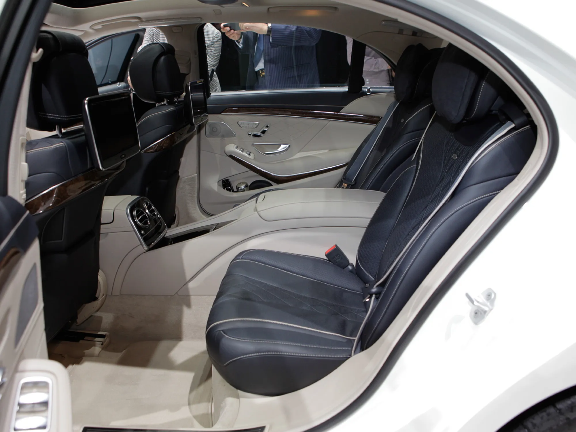 The rear seats of a Mercedes-Benz S-Class (W222) with seat belts, a centre armrest and rear screens