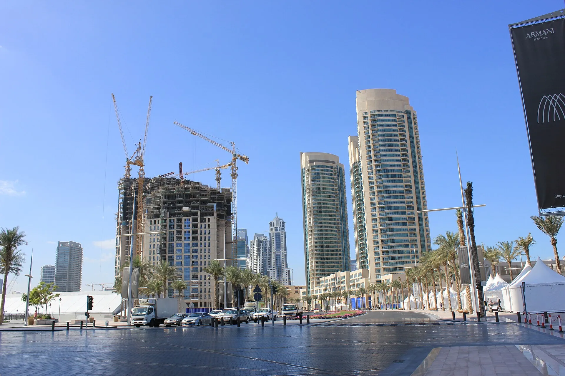 Mohammed Bin Rashid Boulevard in Downtown Dubai, with towers, construction cranes and cars waiting at a junction