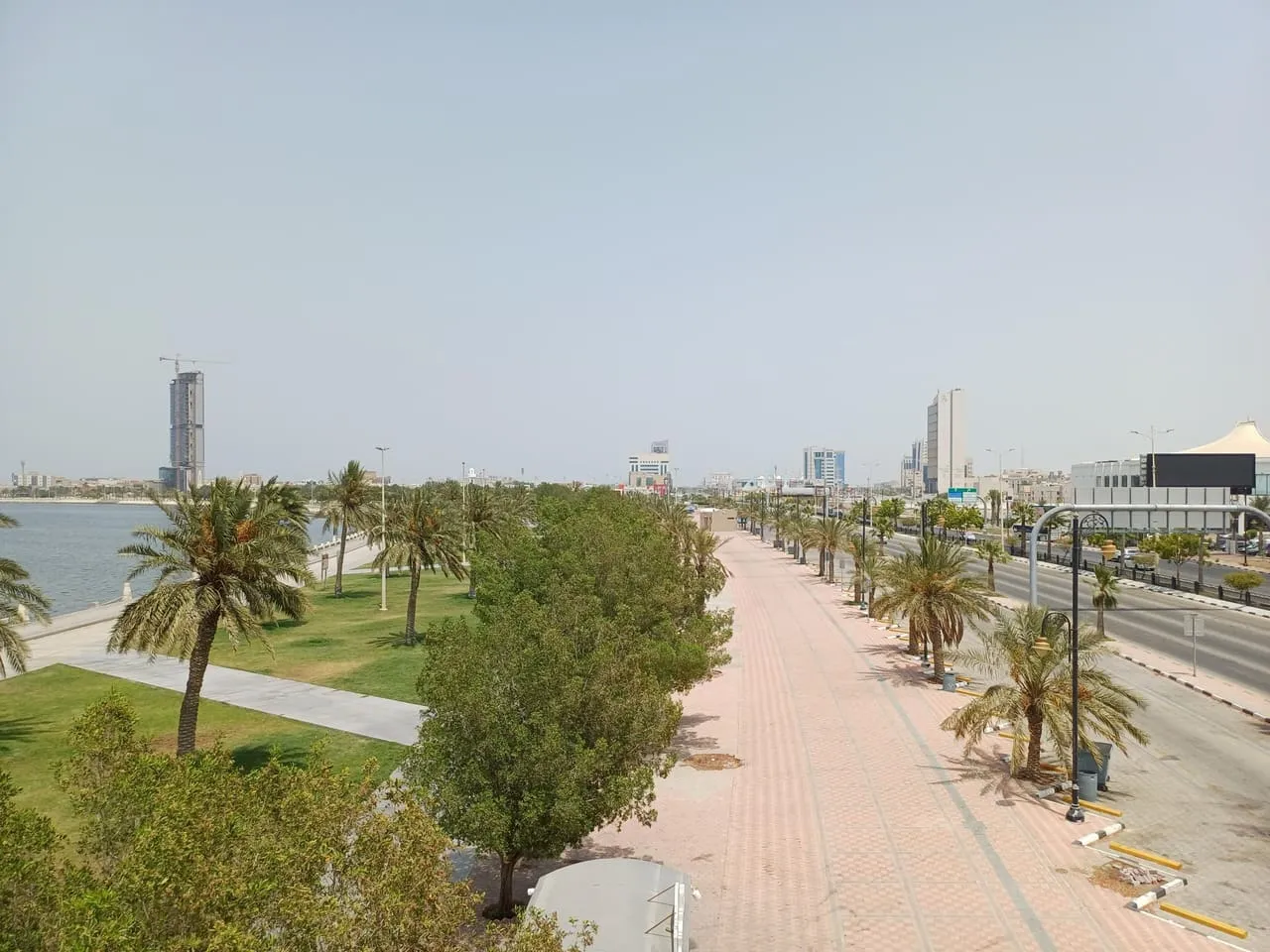 Dammam Corniche in Saudi Arabia, with palm-lined promenade and lawns between the Gulf water and the coast road