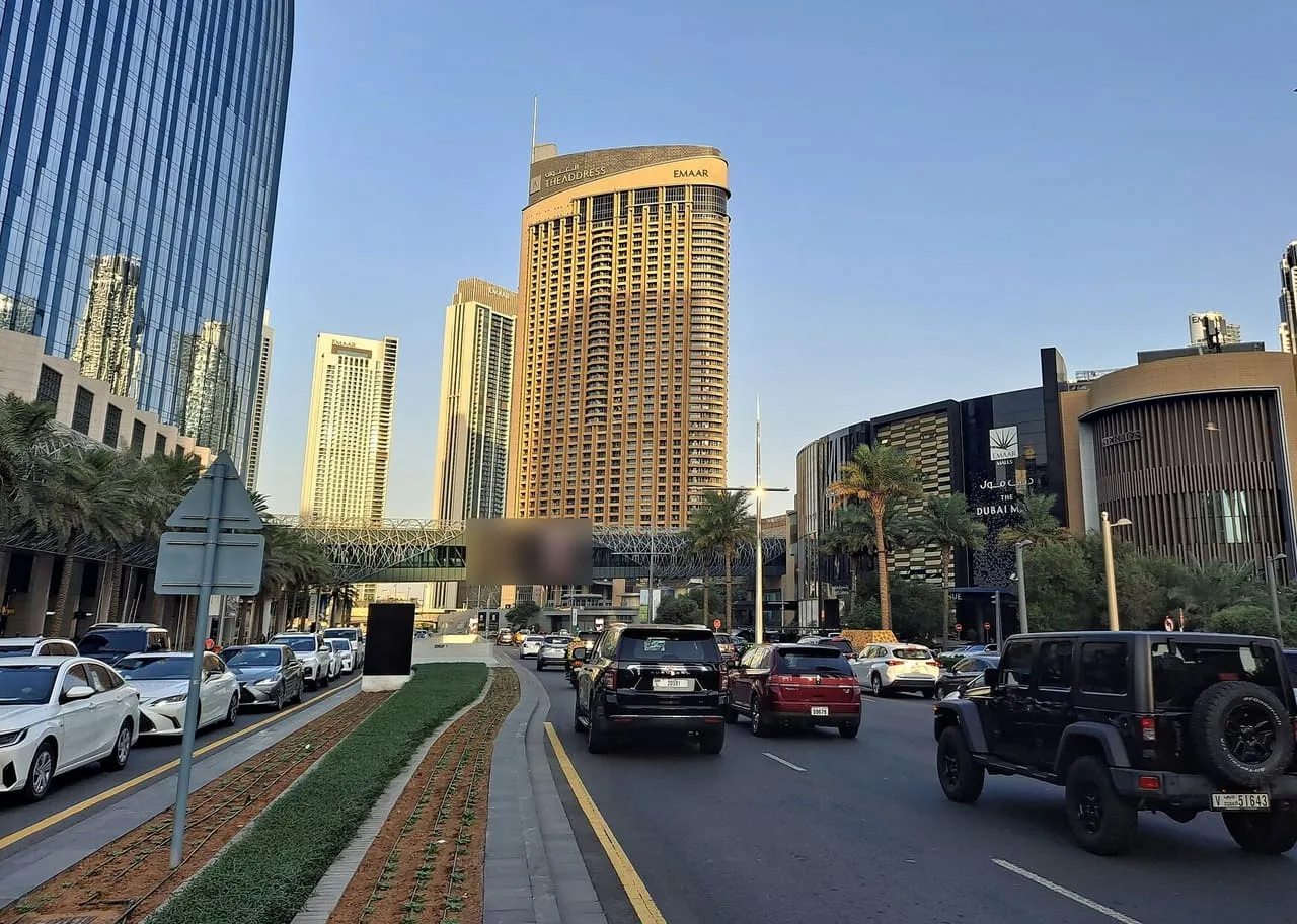 Cars on the road outside The Dubai Mall in Downtown Dubai, with the Address Downtown hotel tower ahead