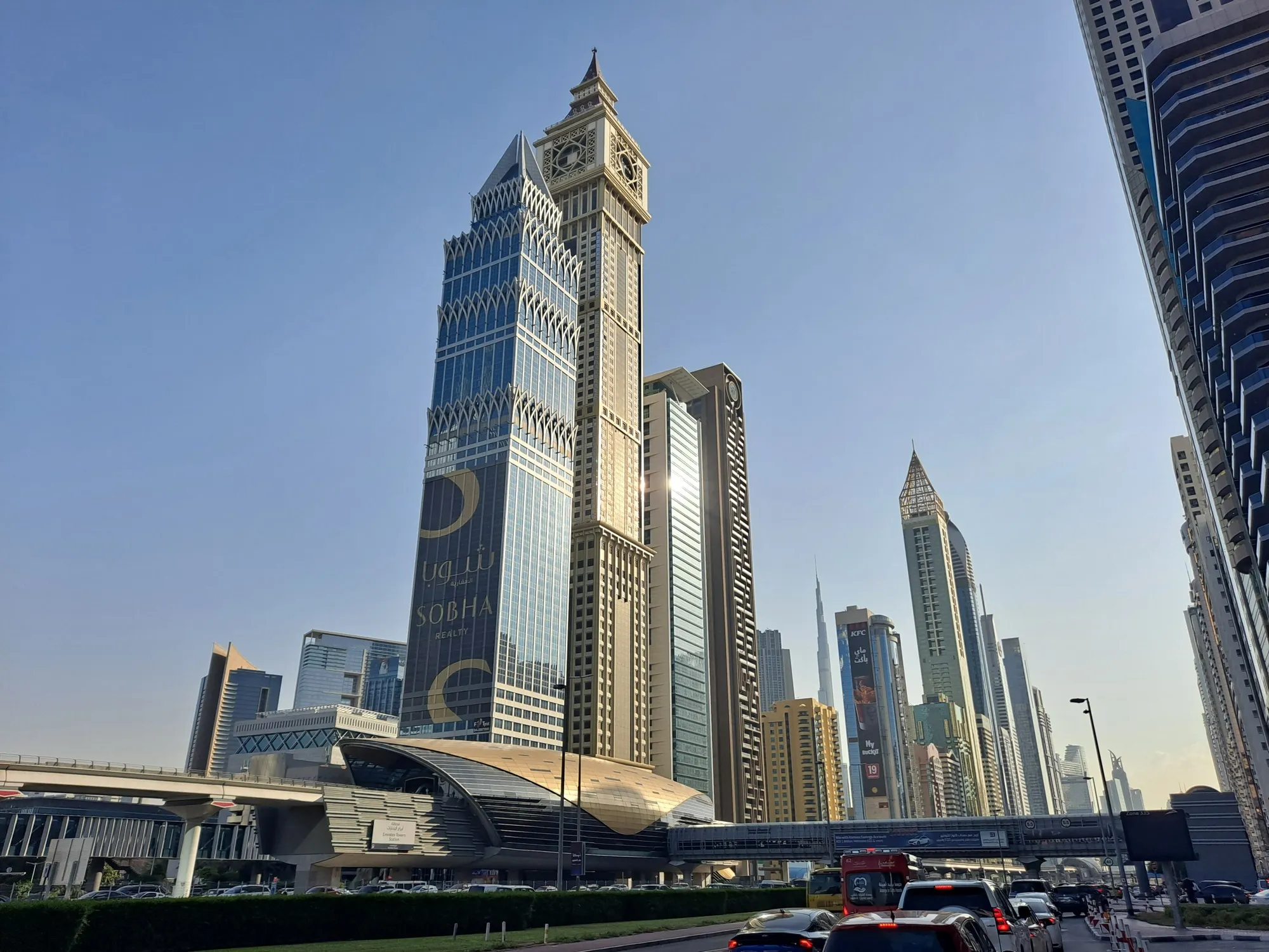Towers and a Dubai Metro station beside Sheikh Zayed Road in Dubai, with traffic in the foreground