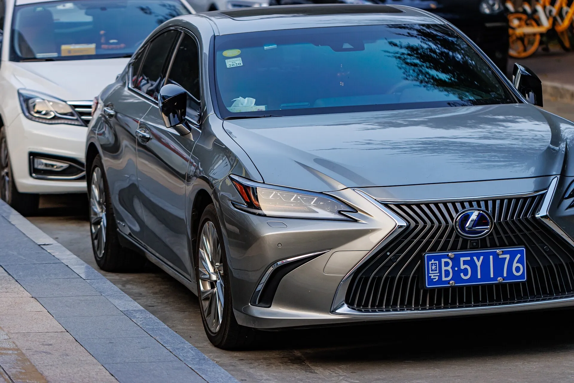 A grey Lexus ES 300h hybrid sedan parked at the kerb, seen from the front