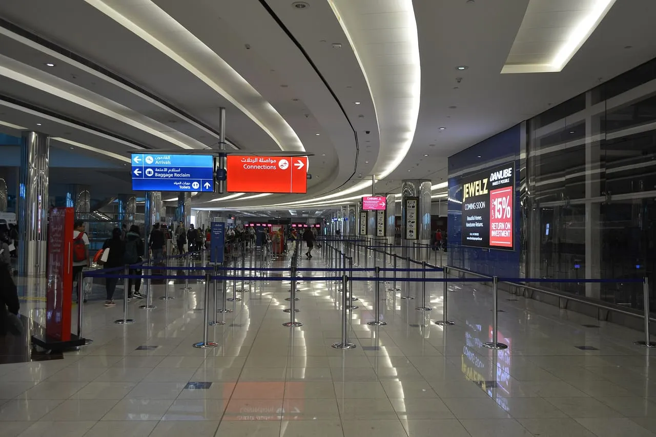 Signs for Arrivals, Baggage Reclaim and Connections above the queue lanes in Concourse B at Dubai International Airport