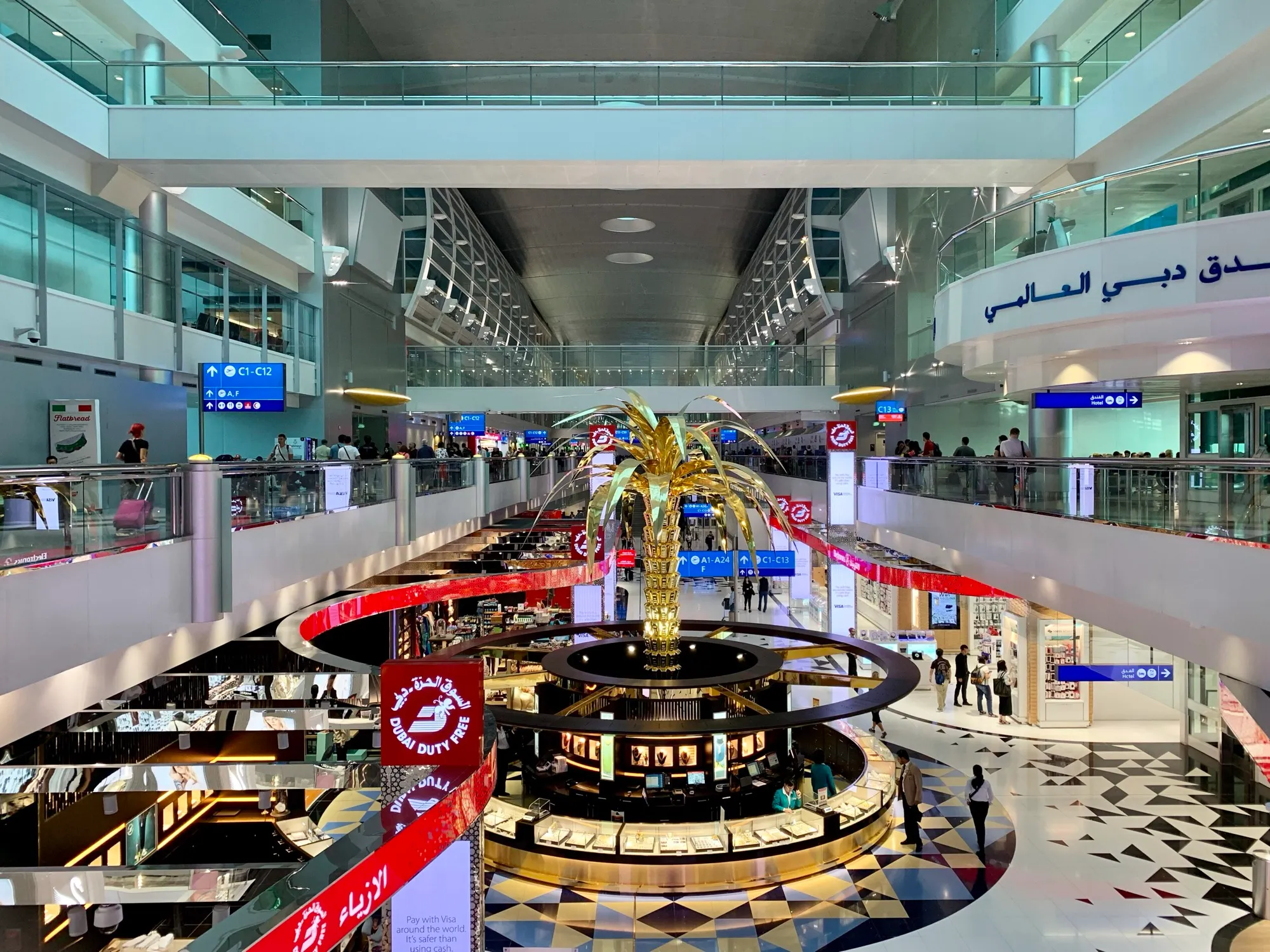 The main concourse of Dubai International Airport Terminal 3, with the golden palm tree sculpture and duty free shops