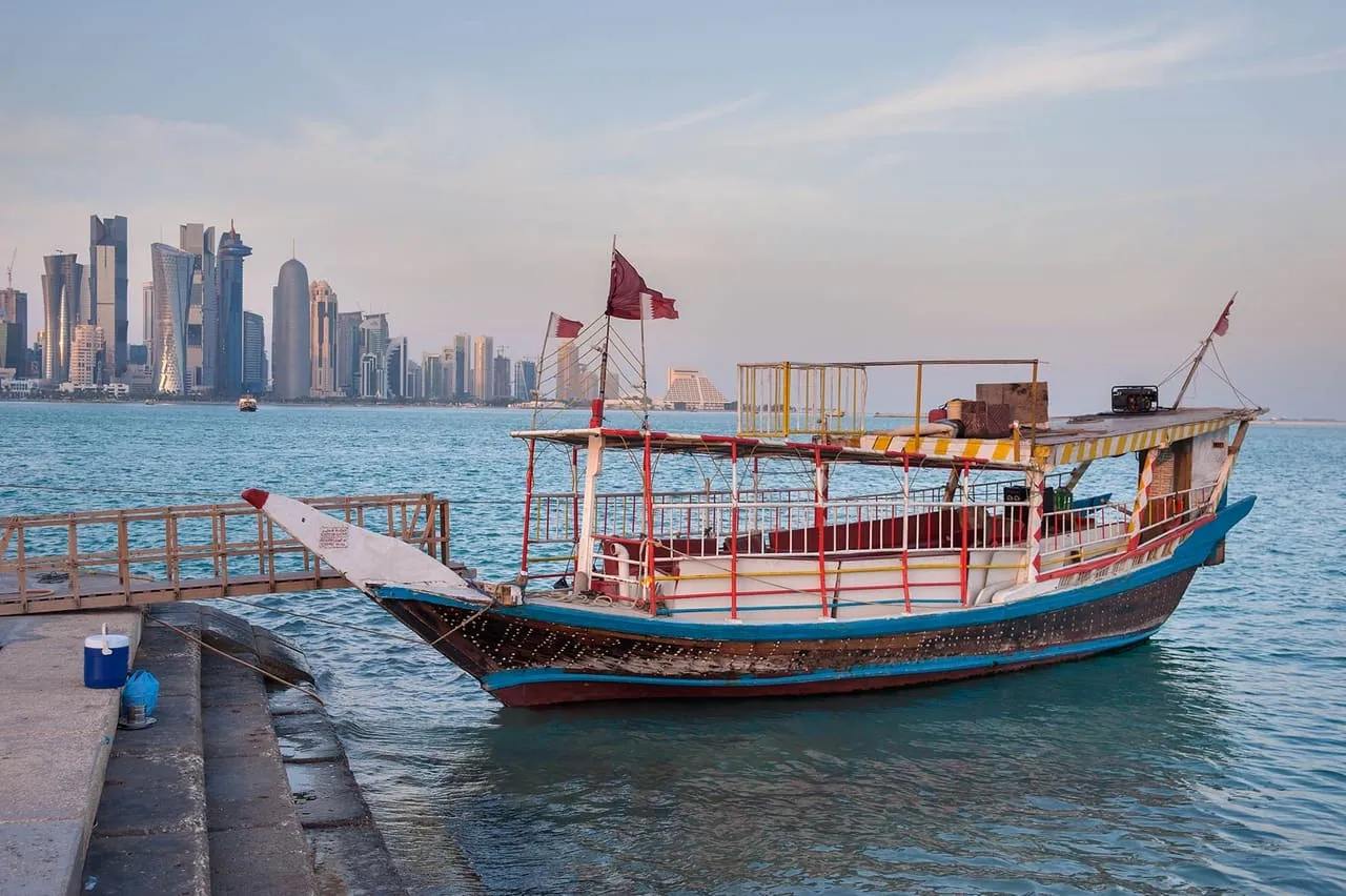 A traditional dhow moored off the Doha Corniche, with the West Bay towers across the water