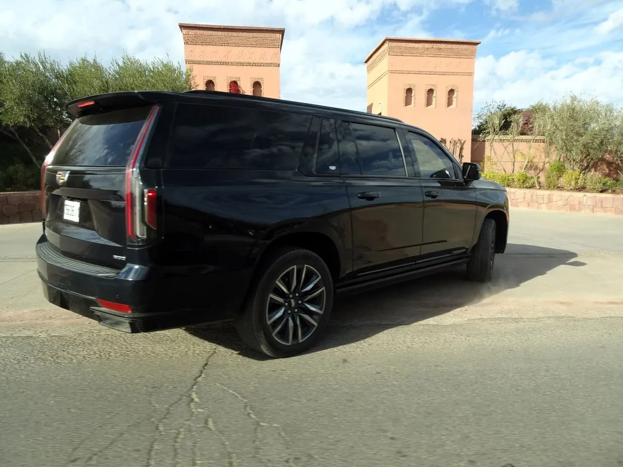 A black Cadillac Escalade ESV, the long-wheelbase Escalade, with tinted rear windows