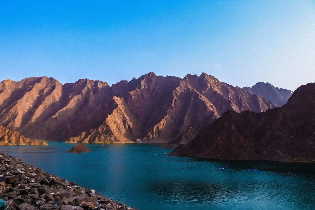 Hatta Dam reservoir surrounded by the bare peaks of the Hajar Mountains in late afternoon light