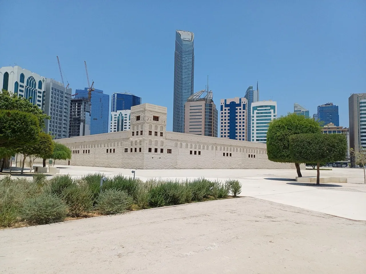 The whitewashed Qasr al-Hosn fort in Abu Dhabi with office towers rising behind it
