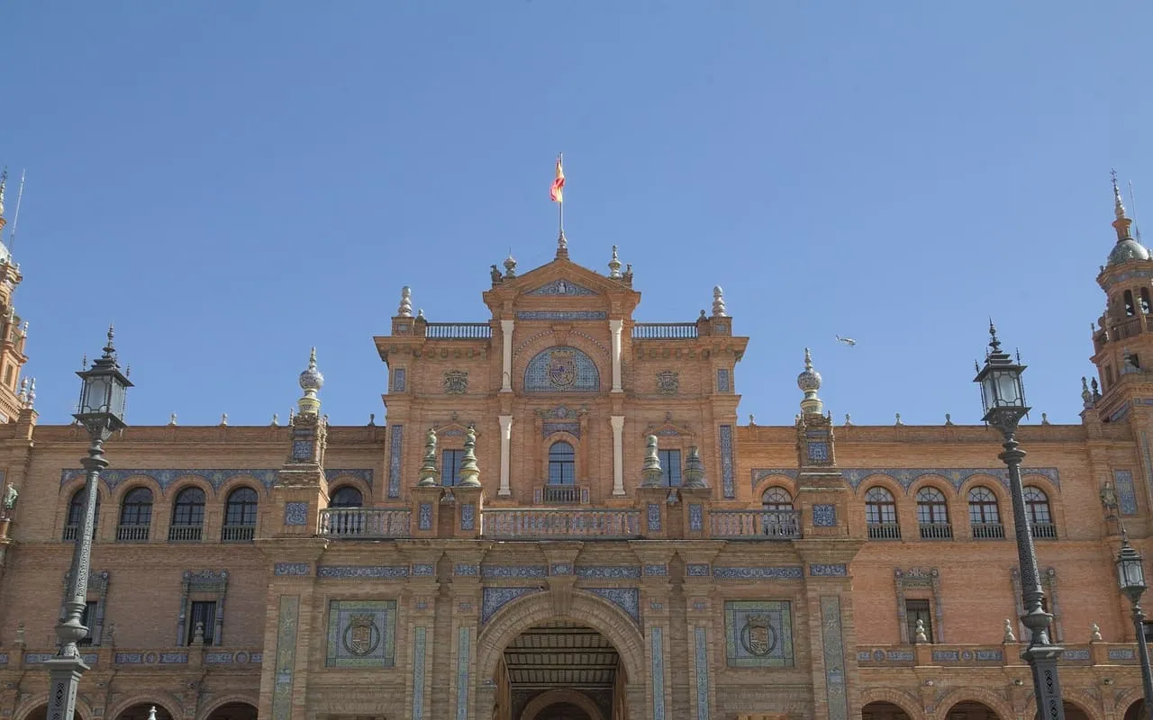 The central building of Plaza de España in Seville, with the Spanish flag on its roof
