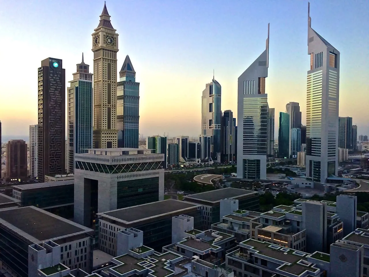 The Gate building in DIFC and the twin Emirates Towers at dawn, with the towers of Sheikh Zayed Road behind