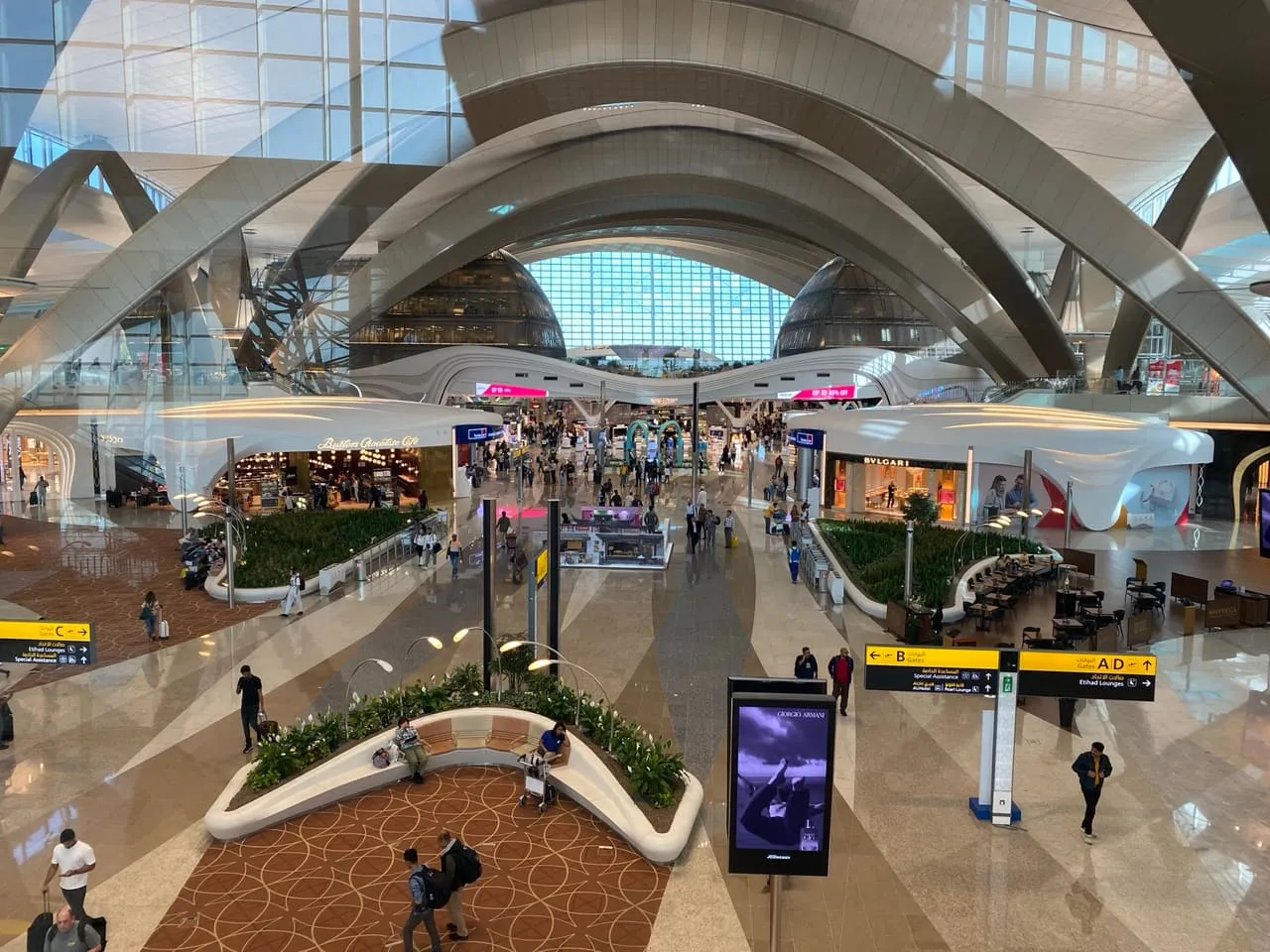 The main hall of Terminal A at Zayed International Airport, with signs to the gates and the Etihad lounges