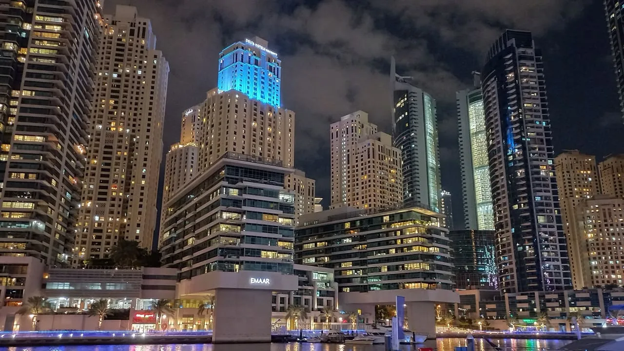 Dubai Marina towers lit up at night above the marina water
