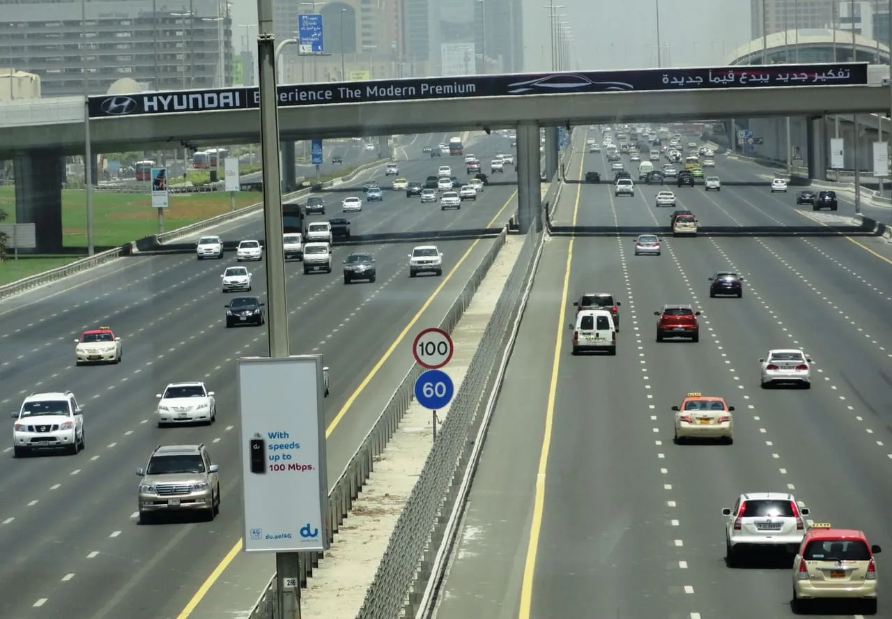 Traffic on Sheikh Zayed Road in Dubai, below signs for the 100 and 60 km/h speed limits