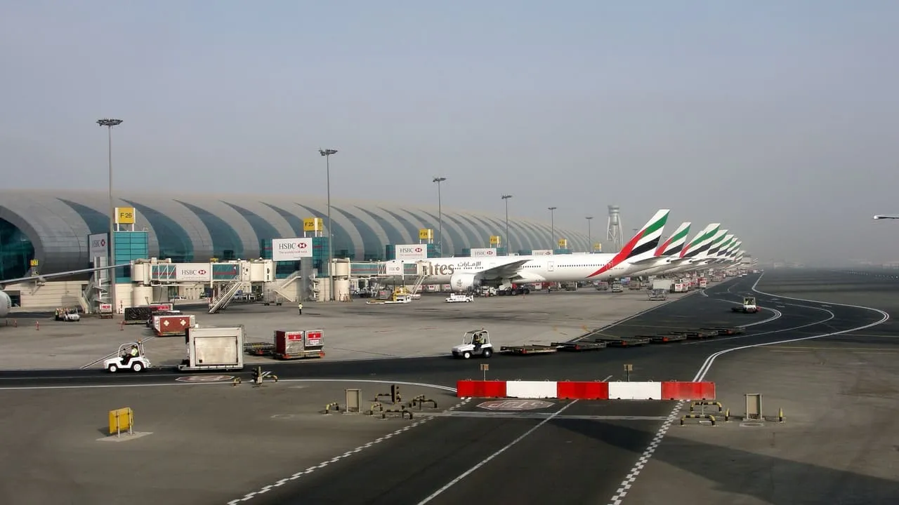 Emirates aircraft parked along the Terminal 3 concourse at Dubai International Airport